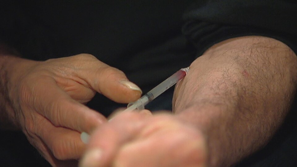 Un homme s'injecte de l’héroïne.