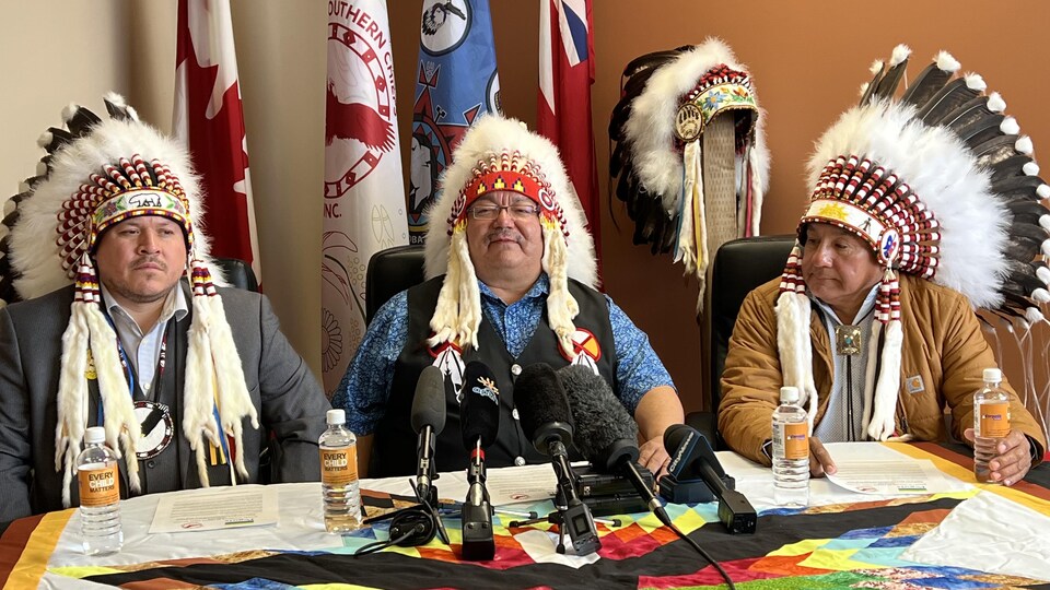 En habit traditionnel se sont réunis (à gauche) le grand chef de l'Organisation des chefs de Sud, Jerry Daniels, (au milieu) le chef de la Première Nation de Peguis, Glenn Hudson, et (à droite) le chef de la Première Nation de Kinonjeoshtegon Rod Travers. 