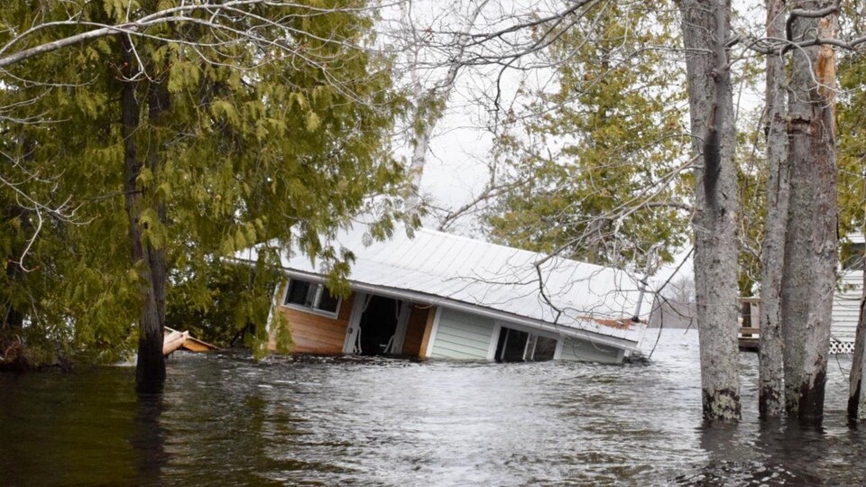 Habitation emportée par les inondations et submergée sur le côté à Princess Park, dans la région de Grand Lake au Nouveau-Brunswick, le 28 avril 2019.