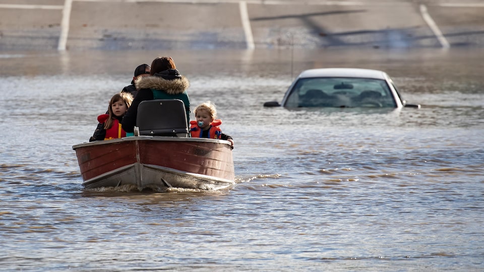 Une femme et des enfants naviguent dans une barque lors d'inondations en C.-B. 