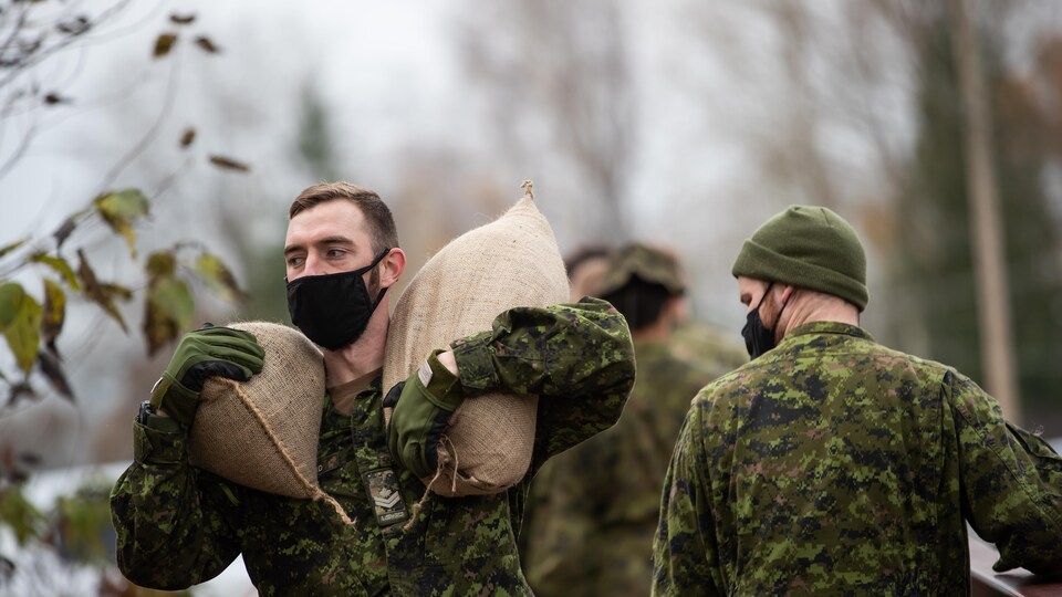 Des militaires transportent des sacs de sable à Abbotsford, en Colombie-Britannique.