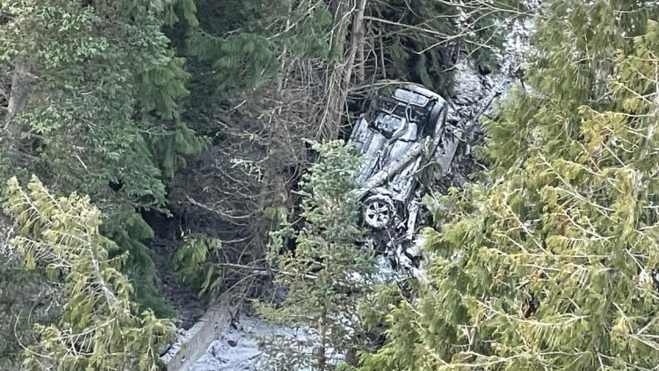 Une voiture à l'envers dans un ravin.