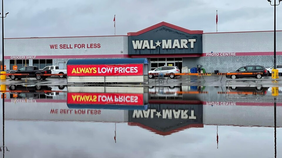 Le logo de Walmart se reflète dans l'eau recouvrant la chaussée. 