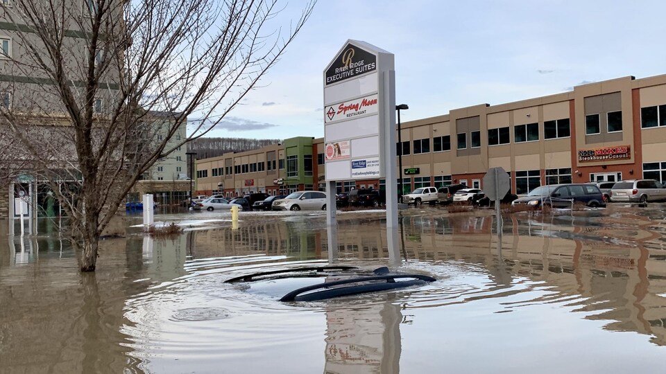 Une voiture sous l'eau pendant des inondations dans un centre-ville.