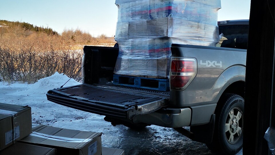 Des piles de boîtes de papier de toilette dans une camionnette.
