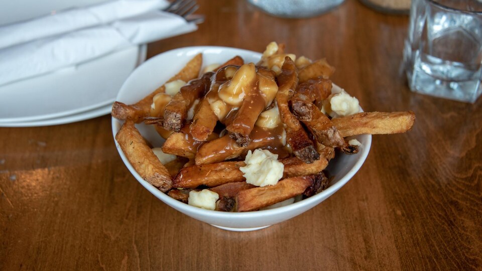 Une poutine dans un bol sur une table