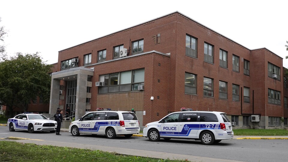 Plusieurs voitures de police stationnées devant le pavillon Burgess de l'Institut universitaire en santé mentale Douglas.