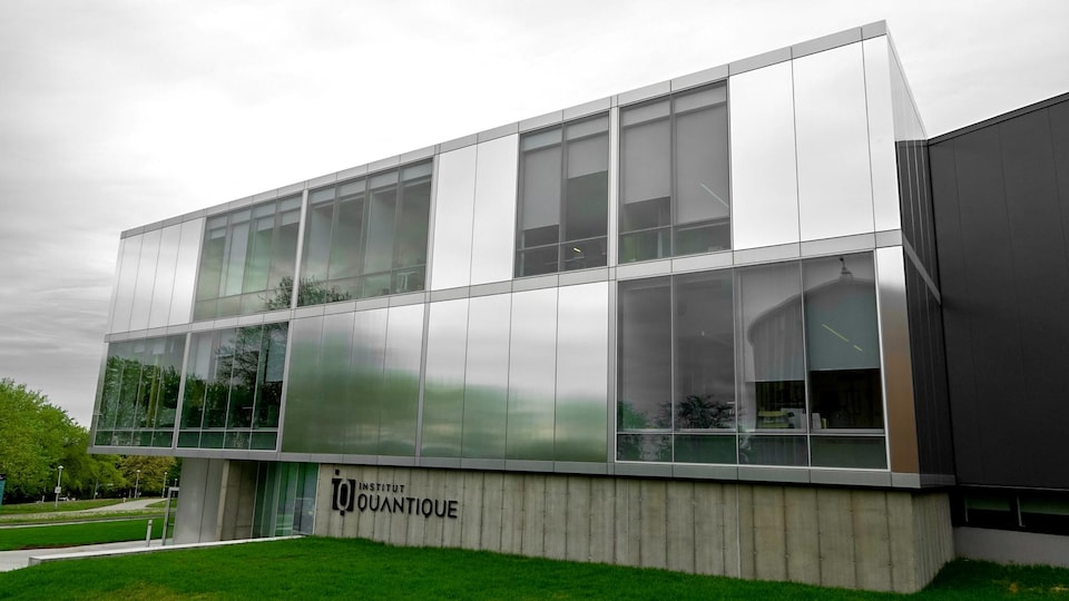 La façade rectangulaire d'un bâtiment avec plusieurs fenêtres. Il s'agit de l'Institut quantique de l'Université de Sherbrooke.