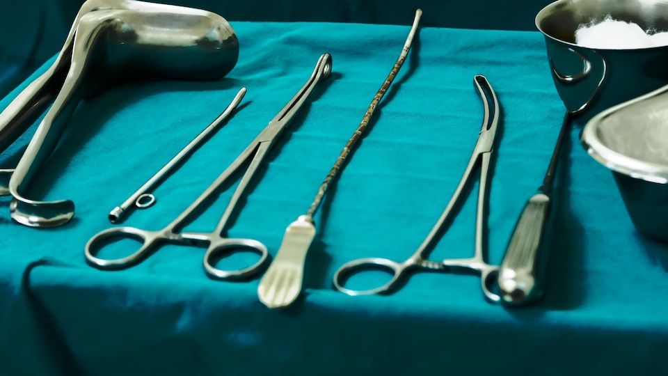 Des instruments de gynécologie posés sur un champ opératoire.