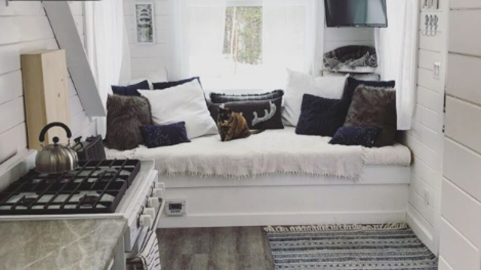 L'intérieur d'une mini-maison avec espace cuisine, un lit et un coin salon.