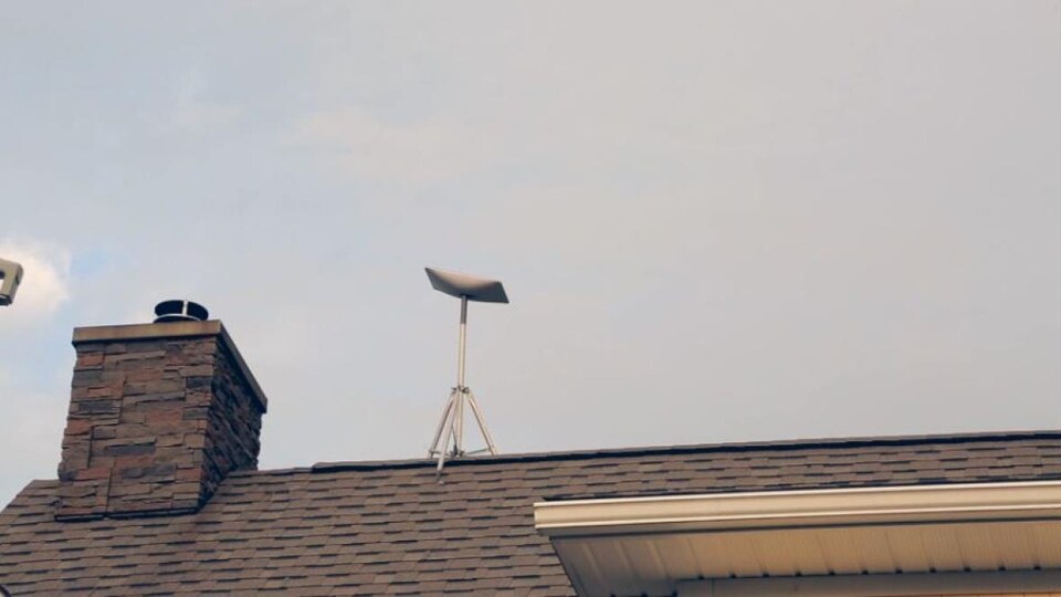 Une antenne parabolique sur le toit d'une maison, au Nouveau-Brunswick.