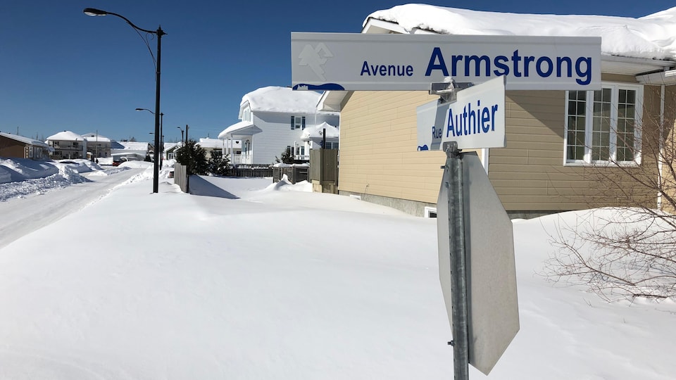 Des écriteaux indiquant le nom des rues Authier et Armstrong sont apposés sur une pancarte d'arrêt, au coin d'une rue.