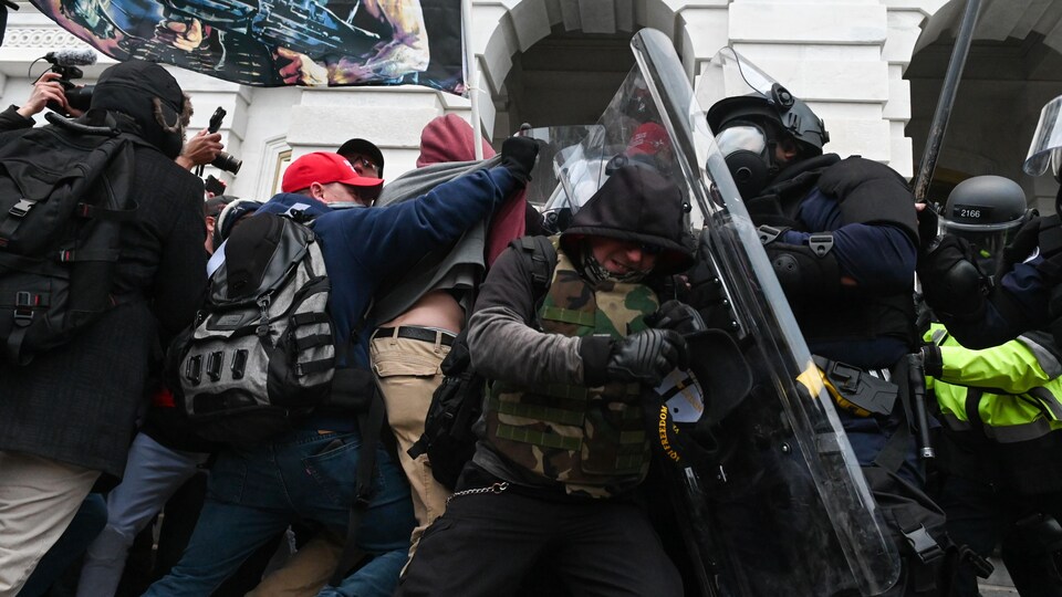 La police antiémeute tente de repousser des manifestants.