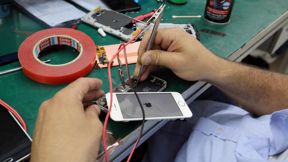 Un technicien répare un iPhone 7.