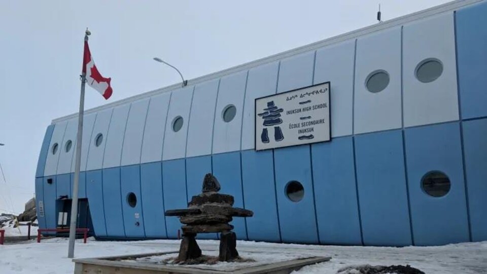 Un inukshuk est érigé devant une école d'Iqaluit, au Nunavut