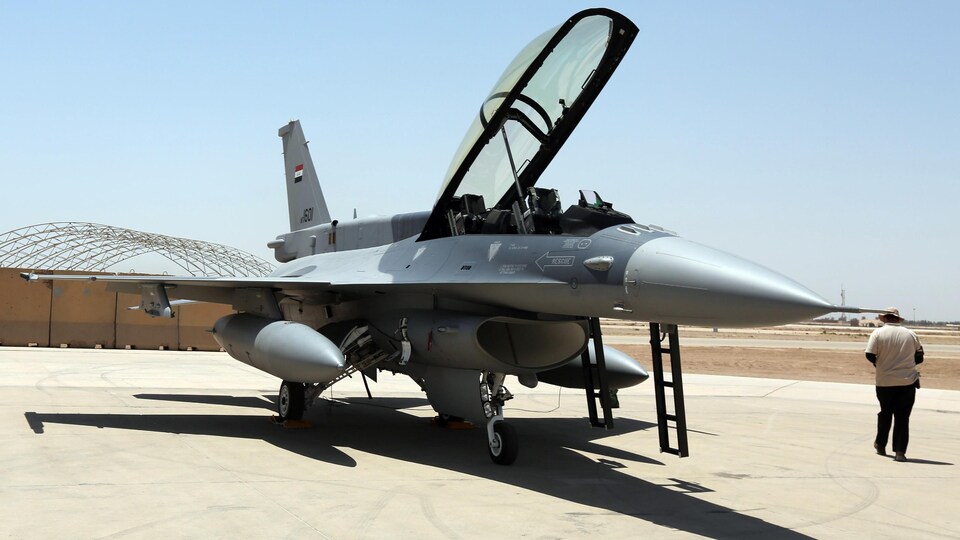 Un avion de chasse stationné sur une base aérienne.