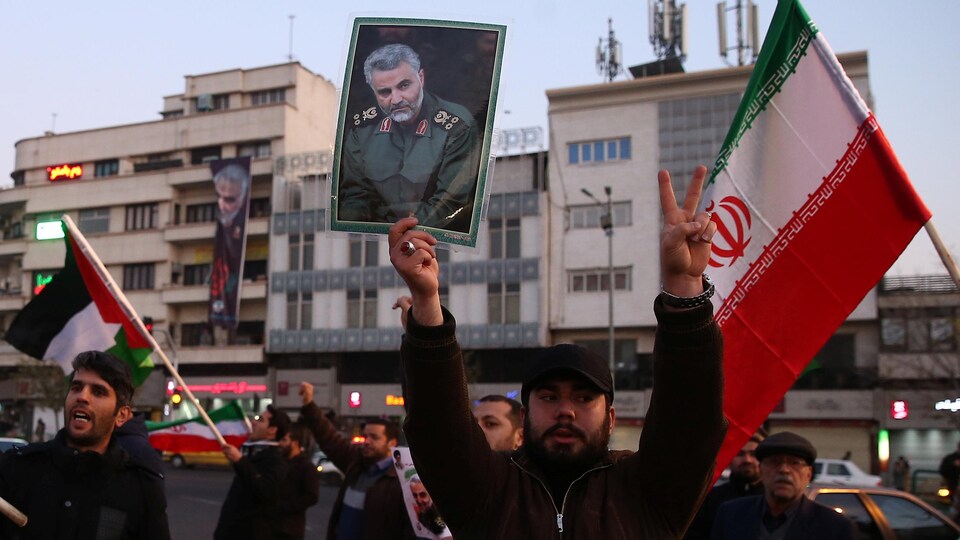 Des Iraniens brandissent des photos du général Soleimani.