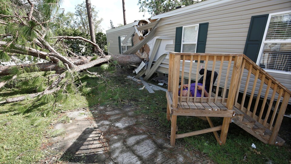 Un homme est étendu près de sa maison détruite par la chute d'un arbre après le passage de l'ouragan Irma, à Kissimmee en Floride.