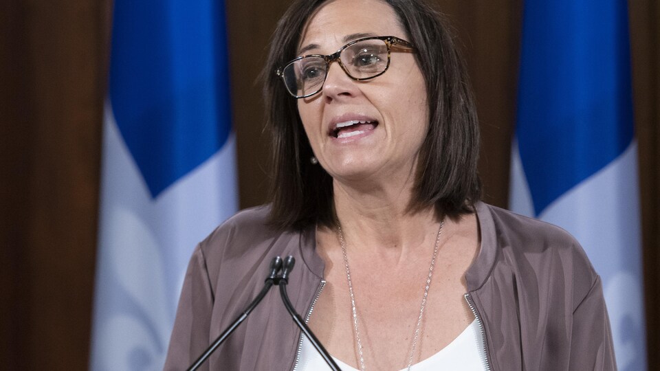 Mme Charest portant des lunettes parle devant un micro.