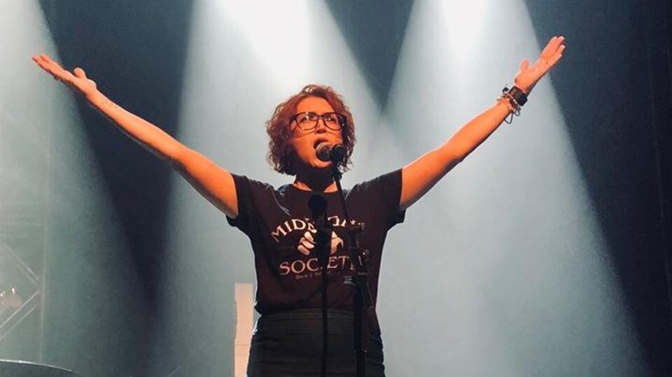 Isabelle Hébert en train de chanter au micro.