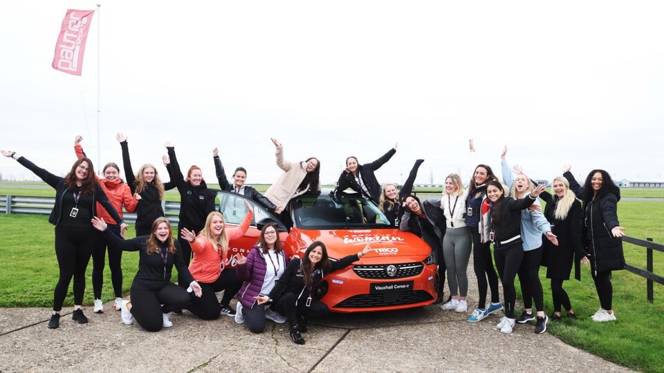 Une vingtaine de finalistes posent pour la caméra autour d'une voiture Formula Woman.