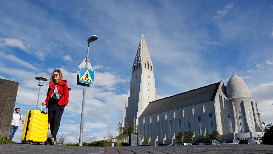 Une femme pousse sa valise en Islande.