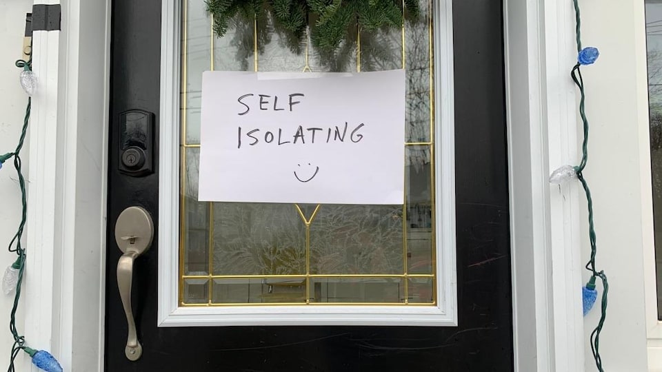 Une porte fermée sur laquelle on peut lire : self isolating.