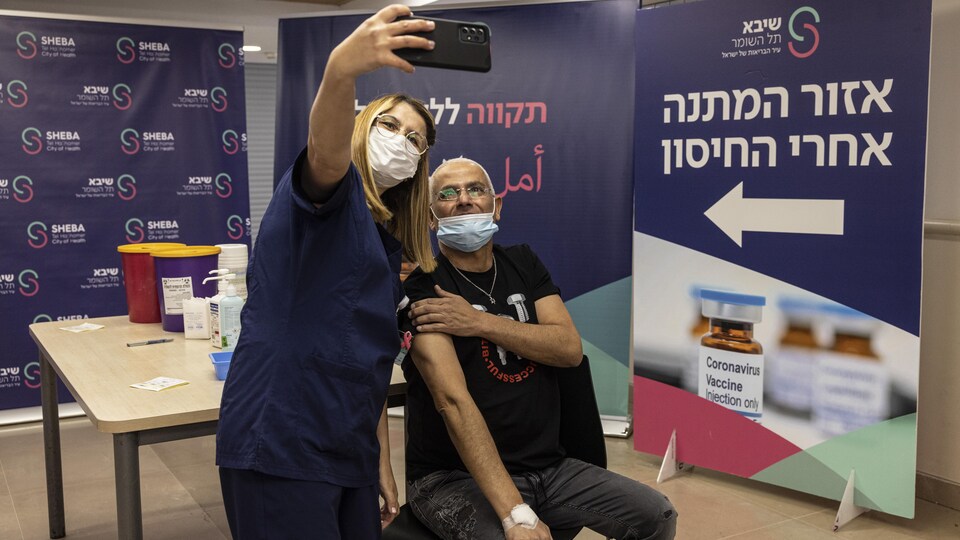 Une infirmière prend un égoportrait avec une personne qu'elle a vaccinée.