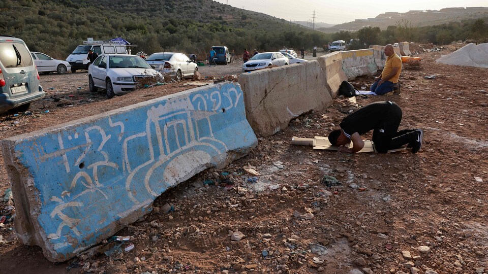 Des palestiniens musulmans font la prière en plein air.