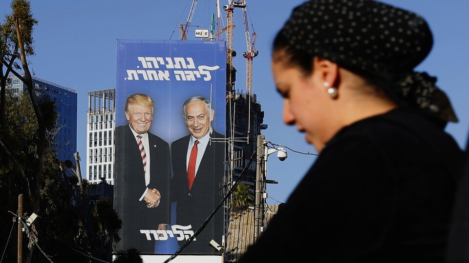 Une femme passe devant l'affiche, sur laquelle est écrit en hébreu: « Nétanyahou, dans une autre ligue ».