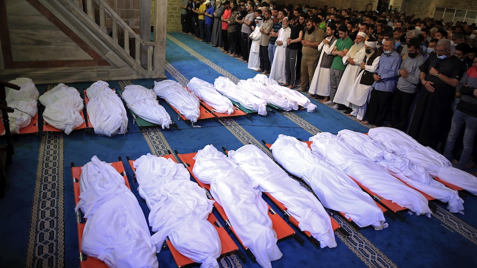 Des Palestiniens recueillis devant les dépouilles de 17 des leurs.