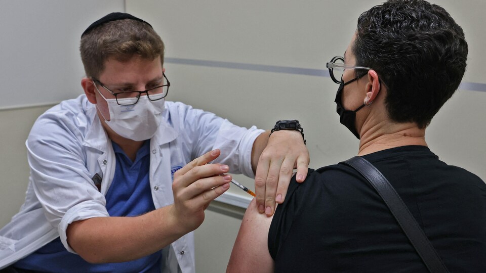 Un agent de santé administre un vaccin à un homme.