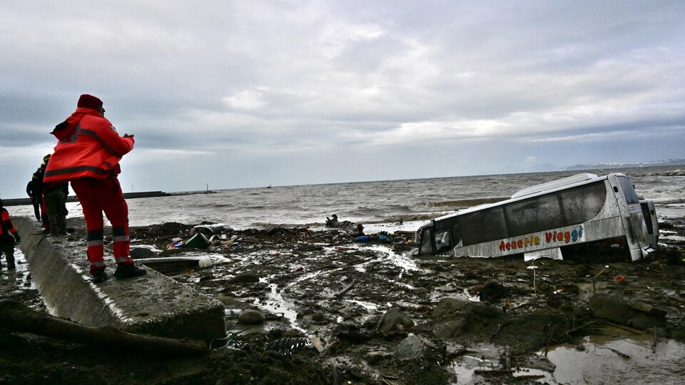 Des secouristes examinent des voitures endommagées sur l'île d'Ischia.