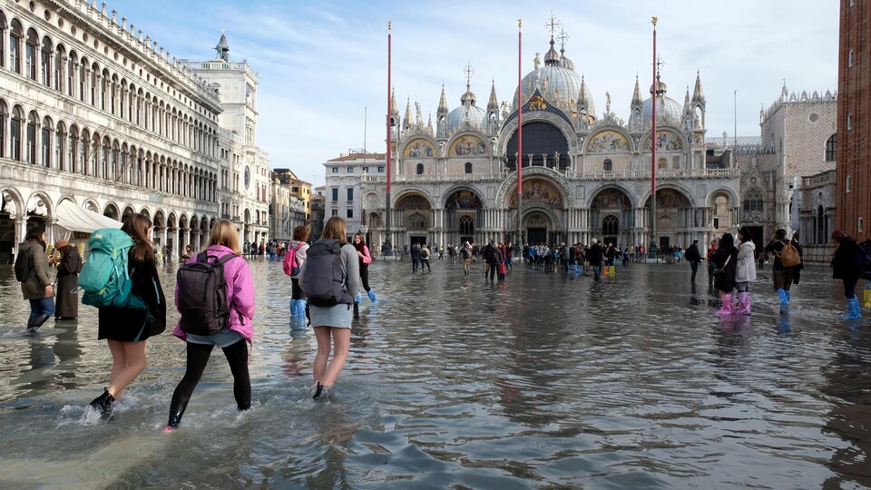 Des gens se déplace dans l'eau à la place Saint-Marc.