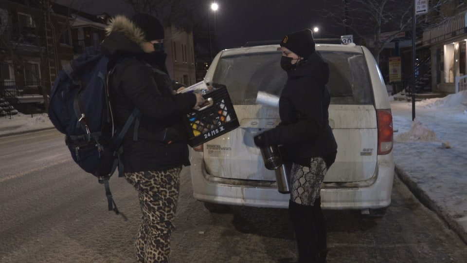 Les deux femmes sortant du matériel d'un véhicule. 