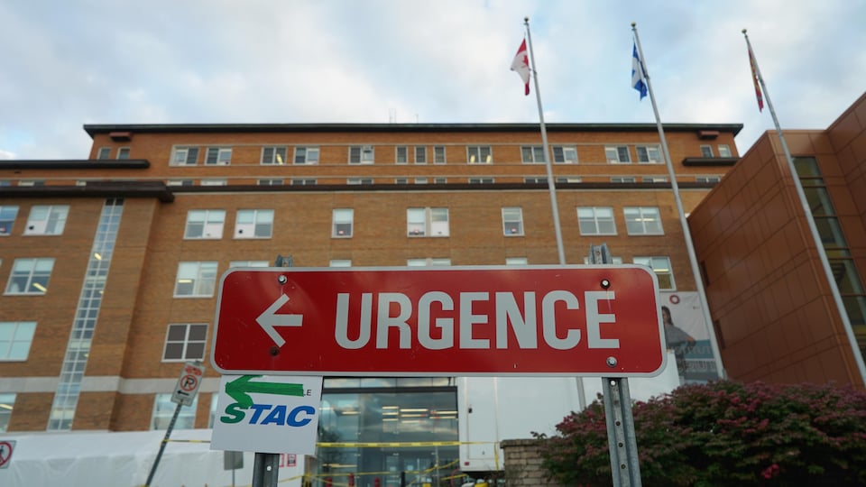 Un panneau Urgence rouge devant la façade d'un hôpital