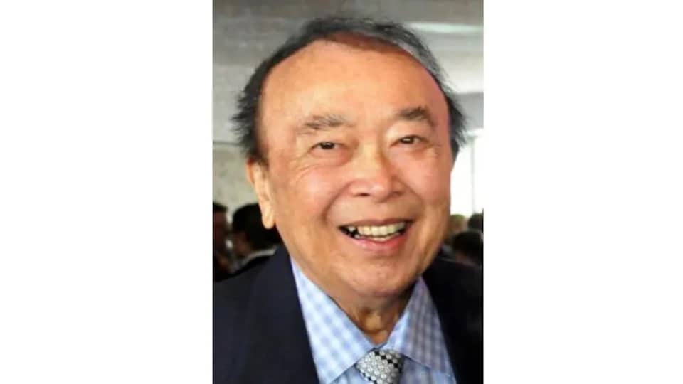 Un vieil homme asiatique en complet cravate sourit.