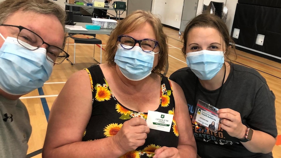 L'infirmière fransaskoise Jacqueline McIlmoyl avec deux personnes venant de recevoir leur deuxième dose de vaccin.