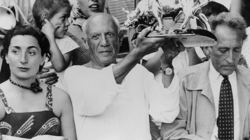 Pablo Picasso tient un trophée représentant un taureau qui lui a été offert par des toréadors.