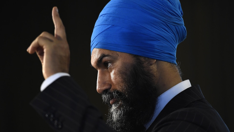 Jagmeet Singh, vu de profil, lève un doigt en l'air.
