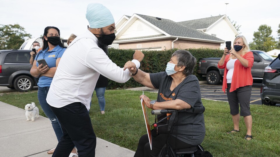Jagmeet Singh salue du coude une femme.