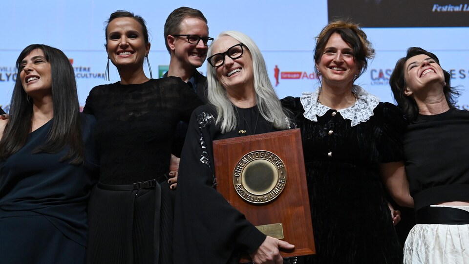 Cinq femmes et un homme côte à côte sur scène lors de la remise d'un prix au Festival Lumière