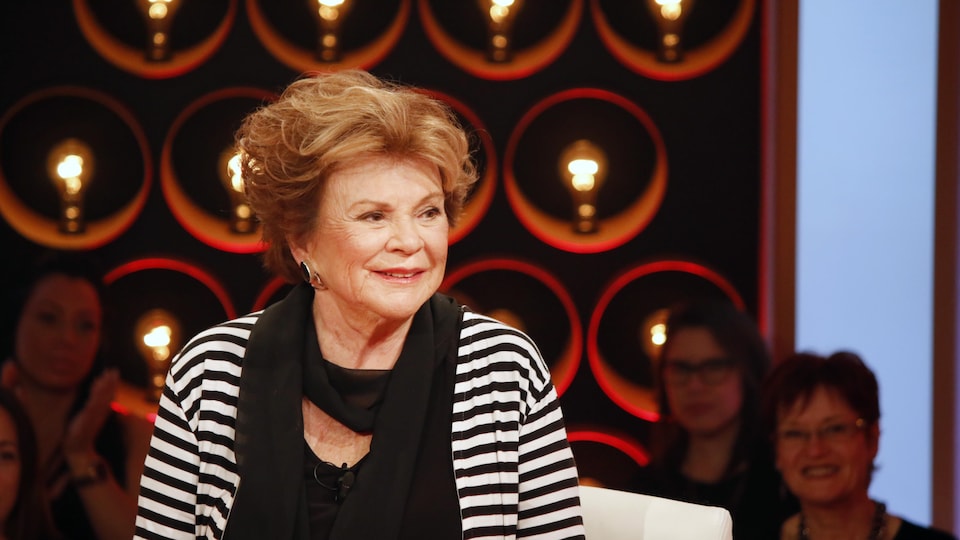 Portrait de l'auteure Janette Bertrand sur un plateau de télévision.