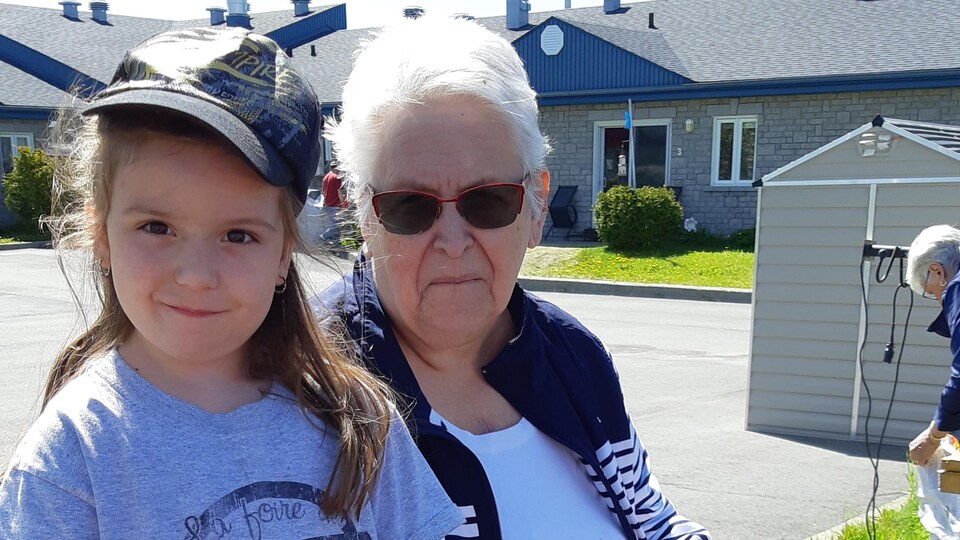 Une personne âgée prend la pose avec une jeune fille à côté du jardin en question.