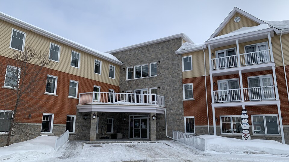 Des voitures sont stationnées devant le complexe immobilier pour personnes retraitées autonomes, Jardins du patrimoine d’Amos.