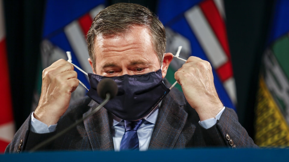 Jason Kenney enlève son masque tout juste avant d'annoncer de nouvelles mesures sanitaires en Alberta. 