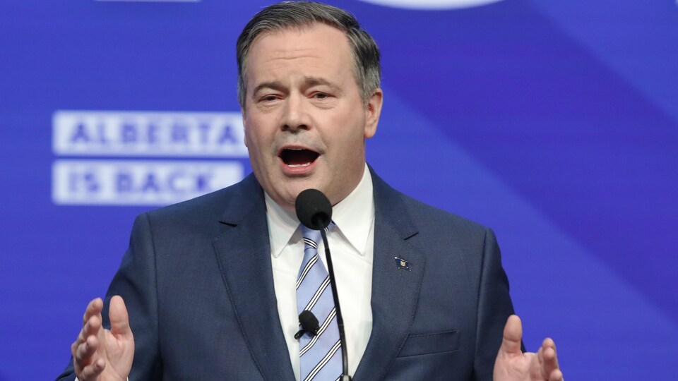 Jason Kenney parle en agitant les mains.