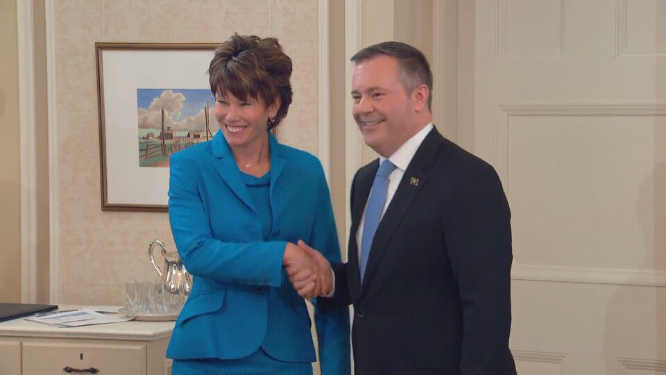 Sonya Savage sert la main de Jason Kenney en souriant.