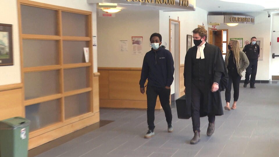 Javon Nsangira et son avocat Derek Bondt déambulent dans les couloirs du palais de justice.