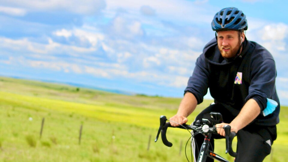 Un jeune homme à vélo.